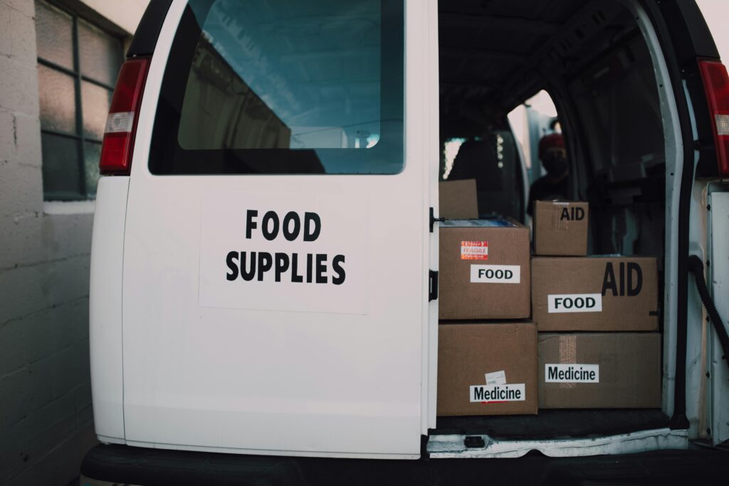 Van loaded with aid supplies and food boxes for charity distribution.